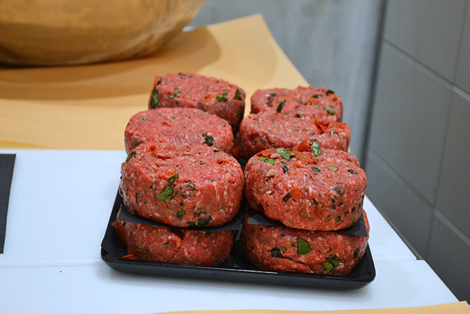 Raw Gourmet Burgers Stacked on a Tray