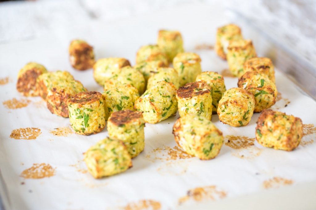 Veggie tots on a baking dish with parchment paper.