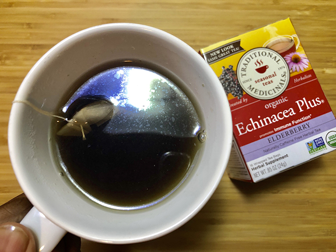Mug with tea next to a box of Traditional Medicinals echinacea plus elderberry tea.
