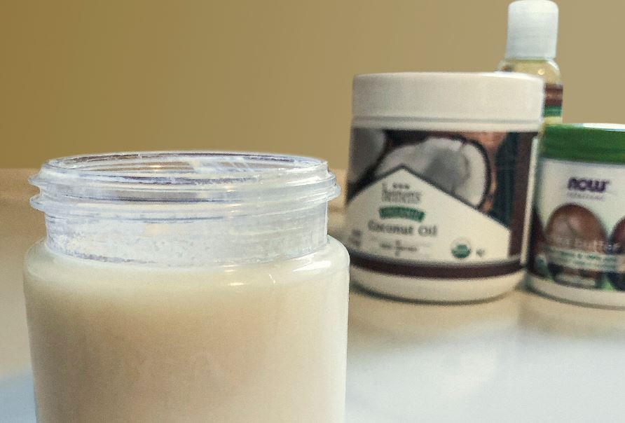 Jar of homemade sunscreen next to containers of coconut oil, shea butter and almond oil.