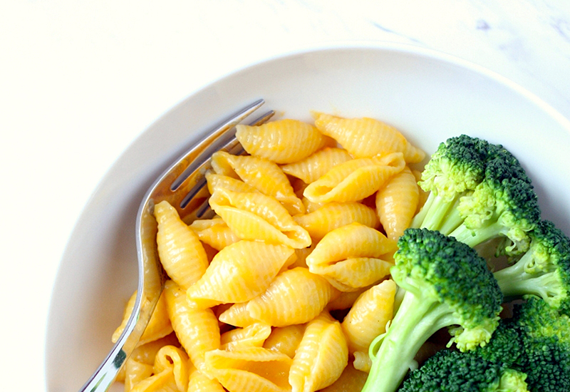 Butternut squash shell mac and cheese on a plate with broccoli.