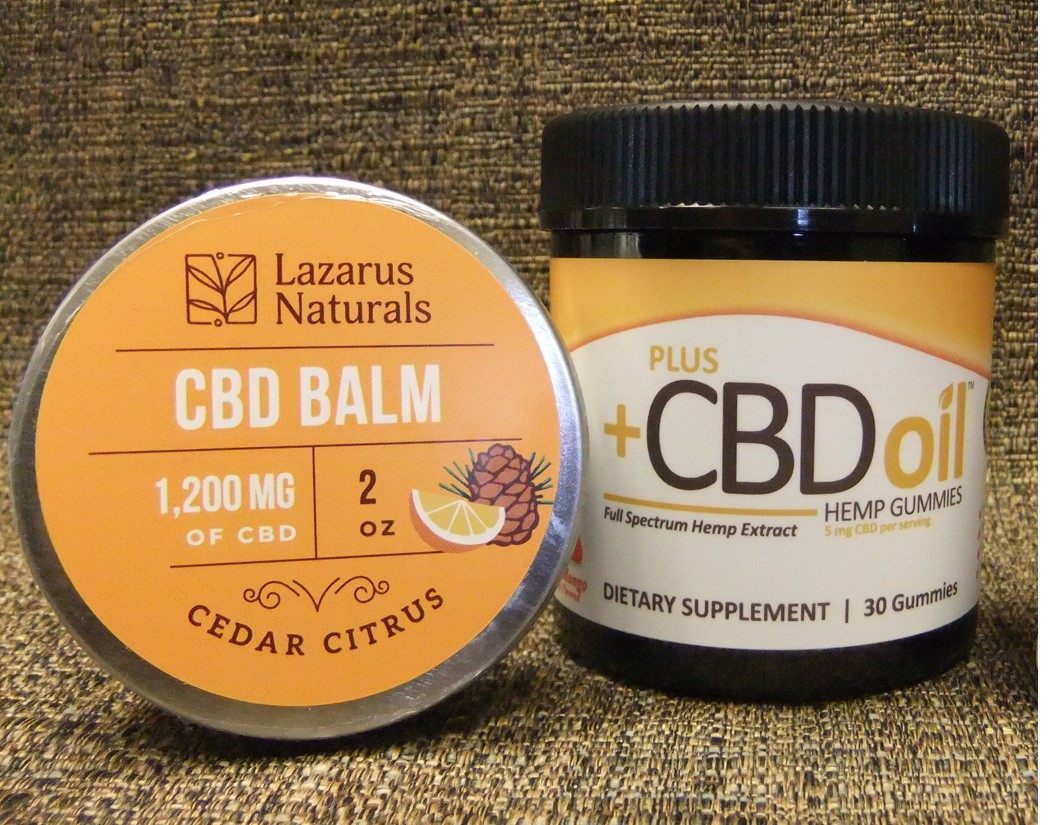 Container of Lazarus Naturals CBD balm next to Plus CBD hemp gummies.