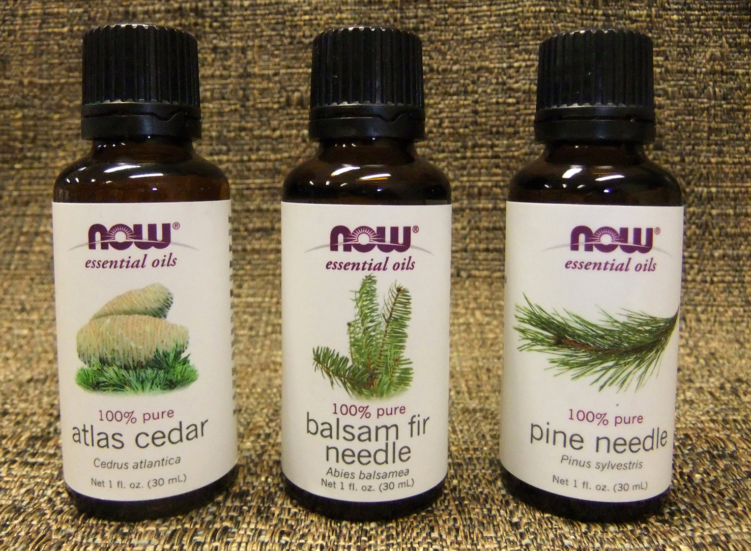 Three Now Essential Oil bottles: atlas cedar, balsam fir needle, and pine needle.