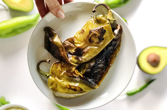 Overhead view of a plate with roasted hatch chiles.