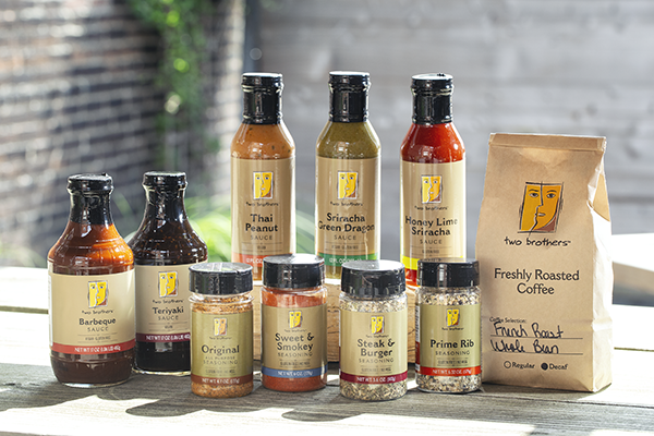 An assortment of Two Brothers products including sauces, seasonings, and freshly roasted coffee.