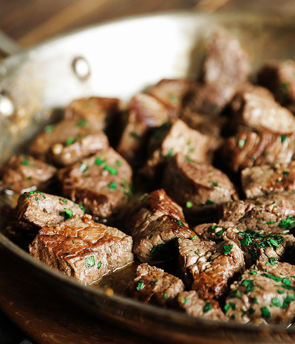 Garlic Steak Bites being cooked in a frying pan.