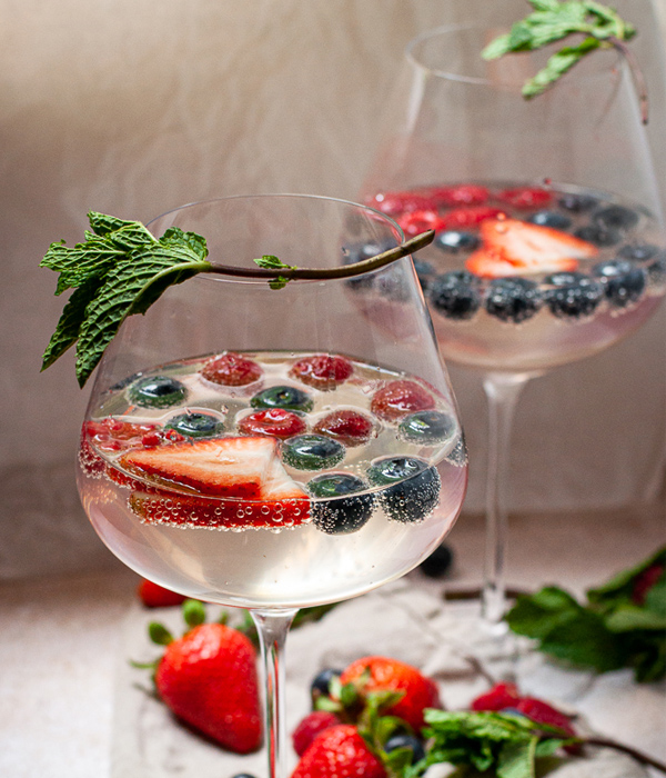 Berry Moscato Punch in wine glasses topped with fresh mint.