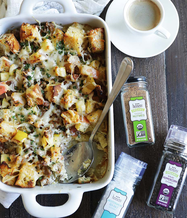 White baking dish with a bread, potato, cheese and herb bake.