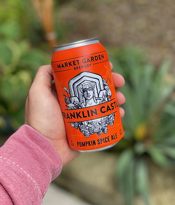 Hand holding a Market Garden Brewery pumpkin spice ale.