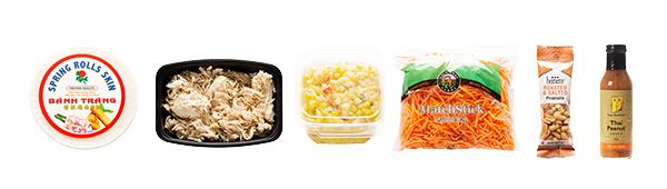 Mango summer roll ingredients including, mango salsa, shredded chicken, Thai peanut sauce, carrots, peanuts, and spring roll wrappers.