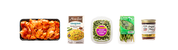 Ingredients for Moroccan Chicken Thighs including marinated chicken, couscous, shelled peas, mint and spices.