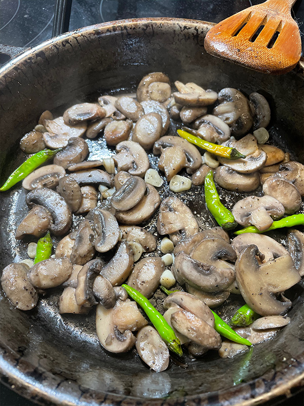 Mushrooms in a cast iron skillet with green chilis.