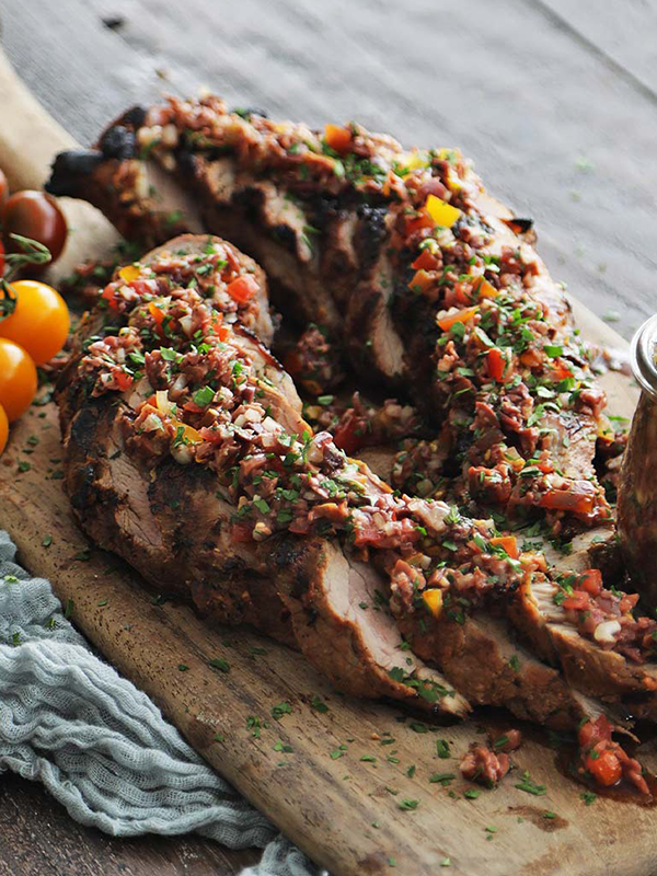 Tuscan Lemon Pork Tenderloin sliced and plated on a cutting board.
