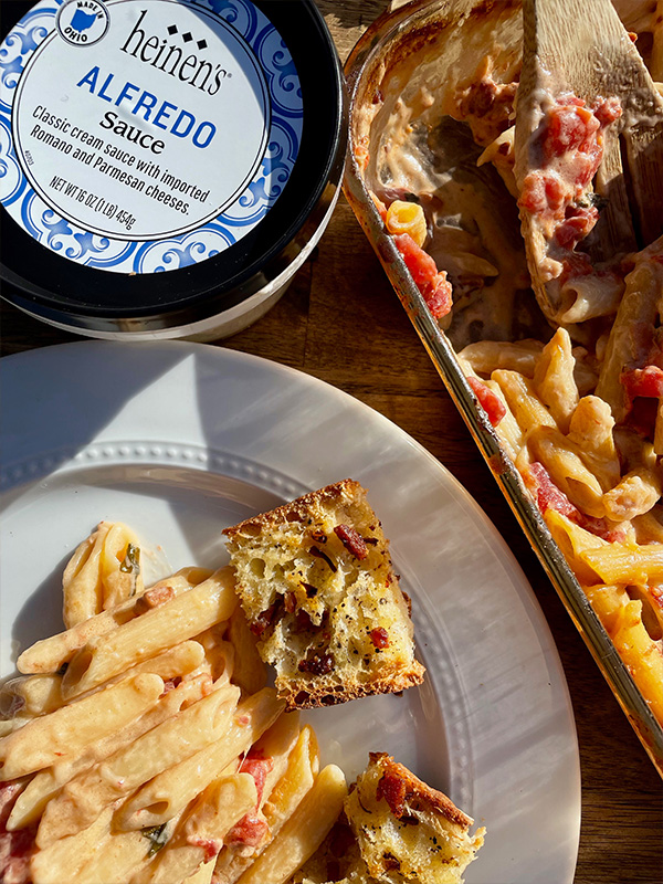 Penne with vodka sauce on a plate with garlic bread.