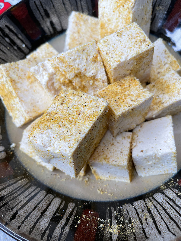 Seasoned tofu cubes on a plate.