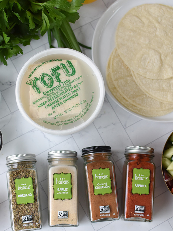 Container of tofu next to tortillas and Heinen's spices.