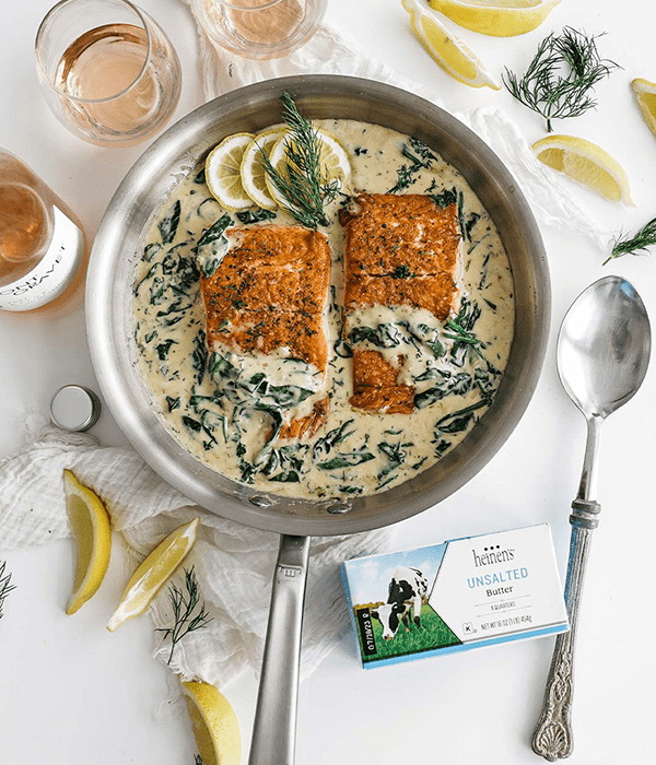 Creamy Rose Salmon in a Skillet Surrounded by Heavy Whipping Cream, Wine, and Fresh Lemons