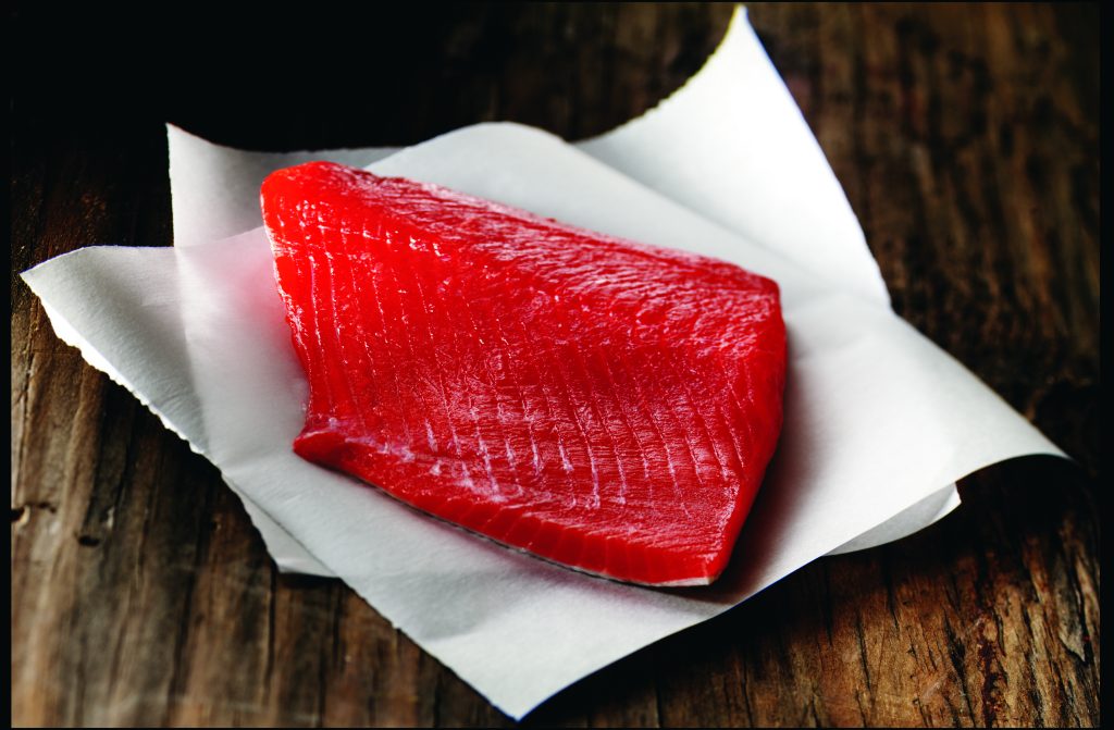 Wild Alaskan sockeye salmon fillet on parchment paper.