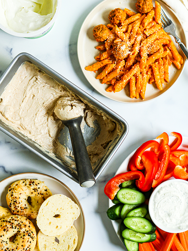 Greek chicken in a skillet with green beans, tomatoes, onions, and a light sauce.