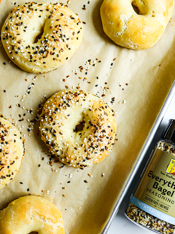 Greek Yogurt Bagels topped with everything bagel seasoning on a baking sheet.