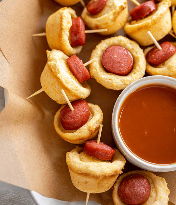 A Close Up Image of Mini Corn Dog Bites with Toothpicks and a Side of Homemade Ketchup