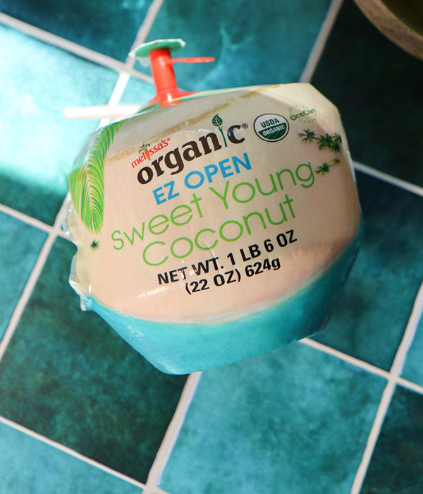 A whole package coconut that says "Ez open sweet young coconut."