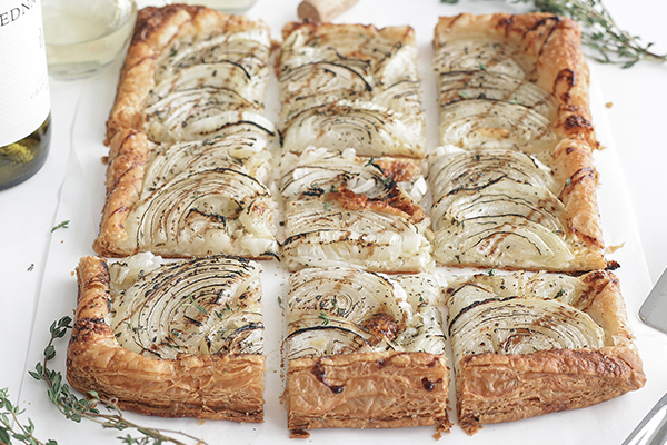 Onion Tart cut into squares and drizzled with balsamic glaze.
