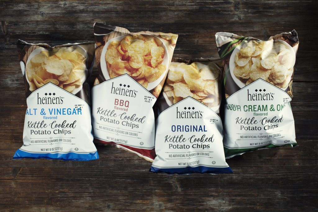 Heinen's Fan-Favorite Kettle Chip bags (original, sour cream & onion, BBQ, and salt & vinegar) arranged in a row.