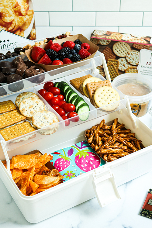 Snackle Box with pretzels, chips, crackers, chocolate, mixed berries, cucumbers, tomatoes and trail mix.