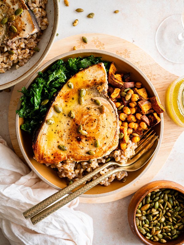 Grain bowl with spinach and chickpeas, topped with swordfish.