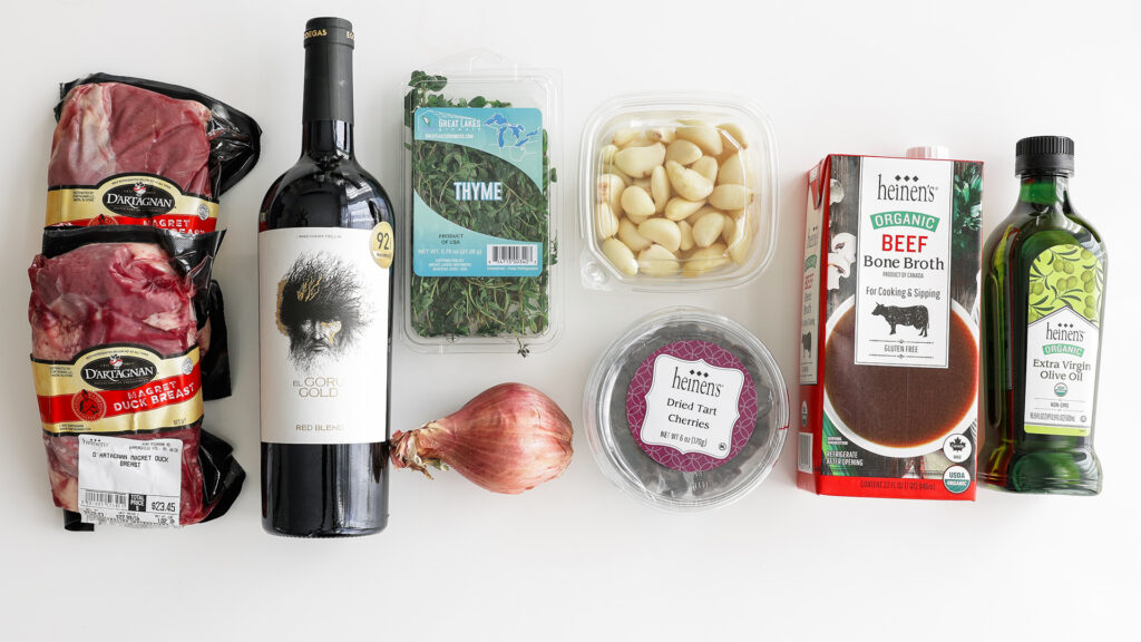 Ingredient spread including duck breasts, wine, thyme, shallots, peeled garlic, dried tart cherries, beef broth and olive oil.