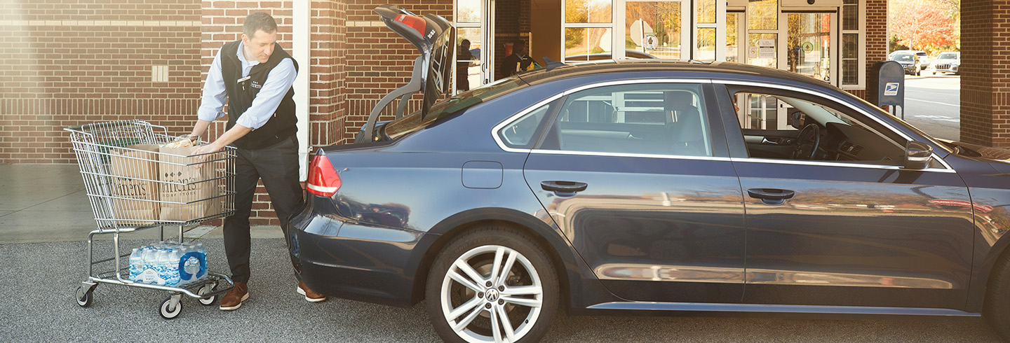 Heinen's worker loading groceries into a customer's car