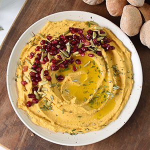 A Bowl of Creamy Pumpkin Hummus with Pomegranate Arils