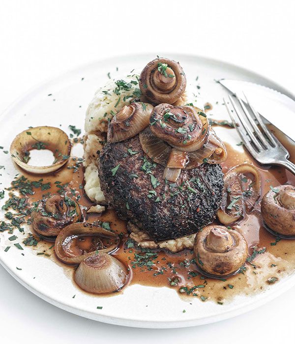 Heinen's Steakhouse Burger on a Layer of Mashed Potatoes with an Onion and Mushroom Sauce