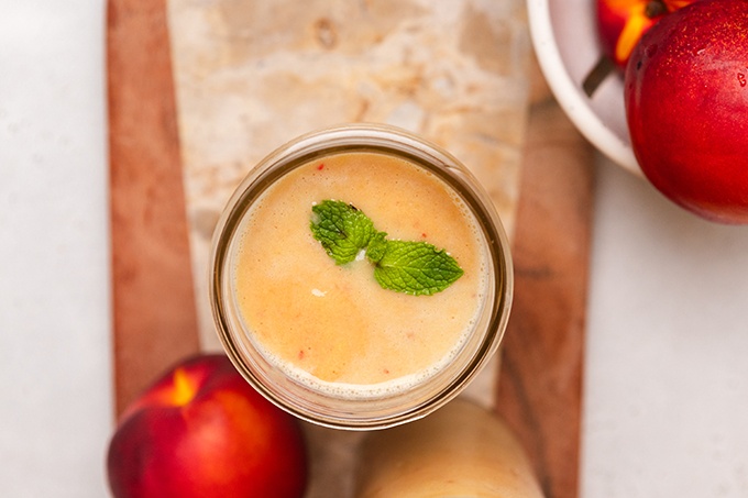 Overhead shot of Ginger Turmeric Smoothie in glass garnished with fresh mint