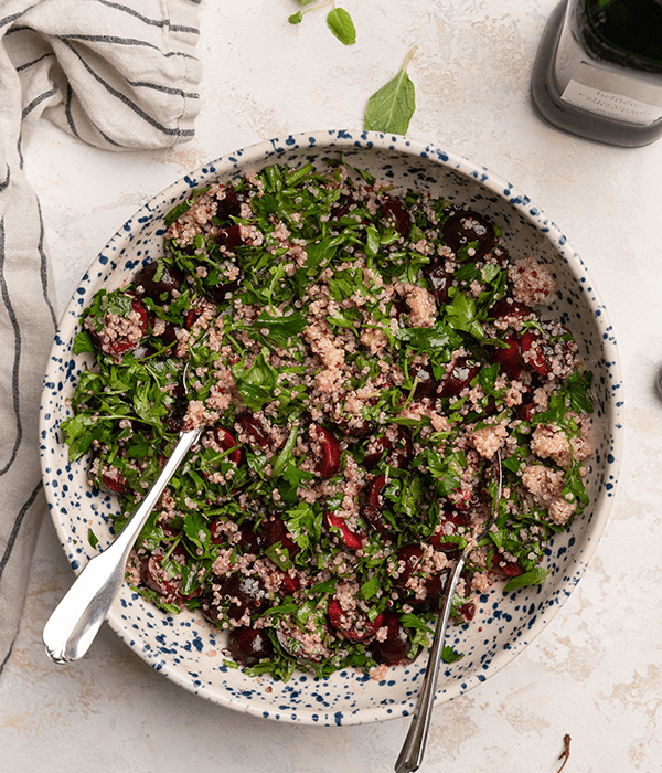 Salad with cherries, mind, parsley and quinoa in a bowl.