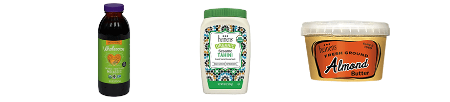 Bottles of Wholesome molasses and Heinen's organic tahini, and a container of Heinen's fresh ground almond butter.