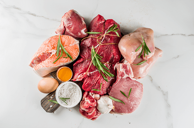 A Top-Down Image of an Assortment of Raw Red Meat, Chicken, Fish, and Dairy Products
