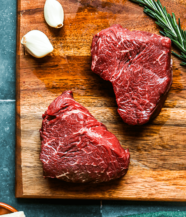 Heinen's Heinen's Raw Premium Sirloin Filets on a Cutting Board with Garlic Cloves