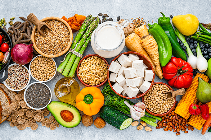 A Top-Down Image of Fresh Fruits, Vegetables, Tofu, Plant-Based Milk, and Legumes