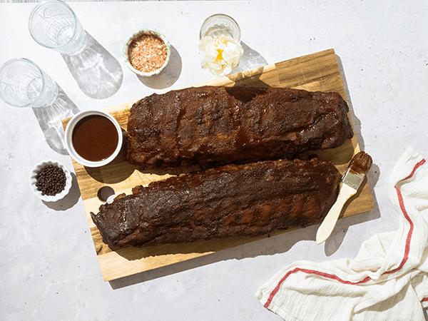 Two Racks of Cooked Baby Back Ribs on a Cutting Board