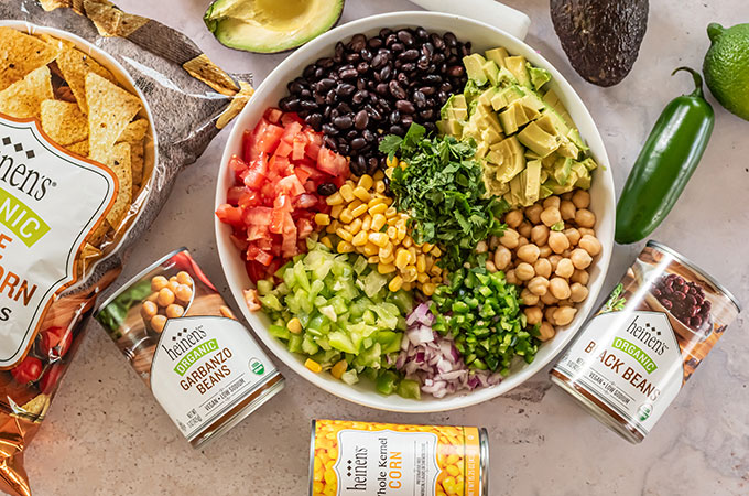 Heinen's tortilla chips, garbanzo beans, corn, black beans and bowl with beans, avocado, tomatoes, green pepper, jalapeno, cilantro, corn, and onions