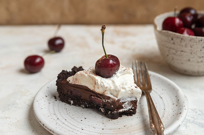Slice of No-Bake Chocolate Cherry Tart on a plate with a fork