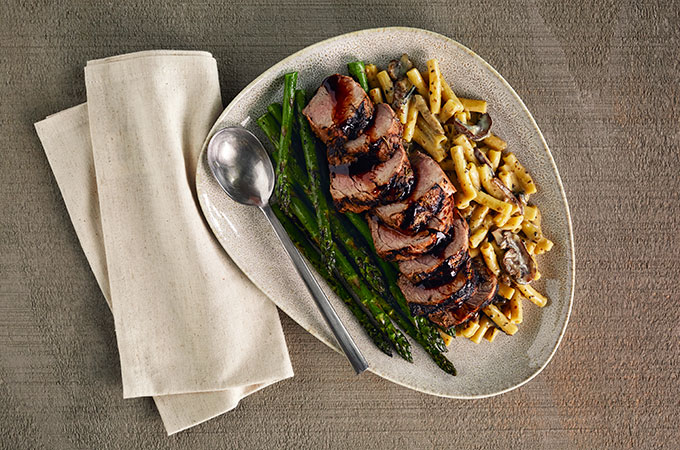Plate of rosemary roast pork tenderloin with truffle mac & cheese