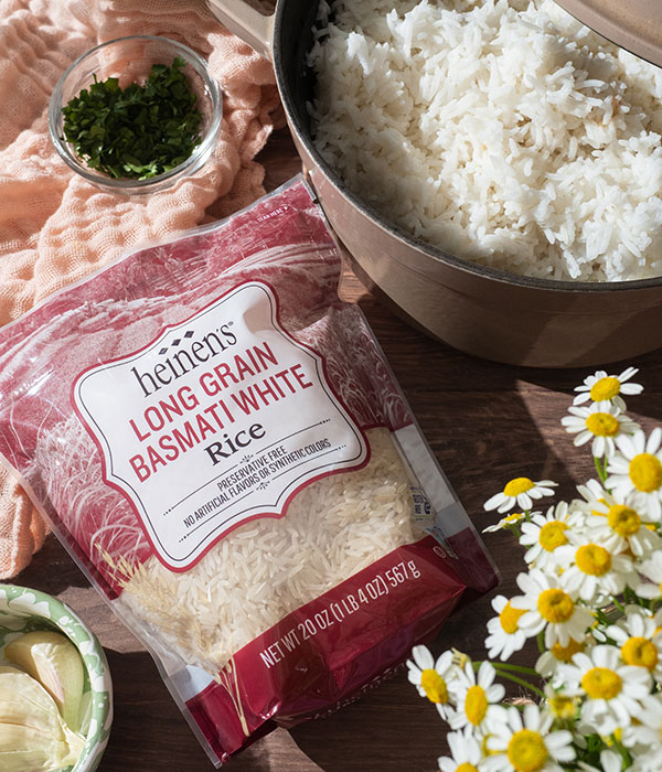 Bag of Heinen's Long Grain Basmati White Rice, next to a bowl of cooked rice