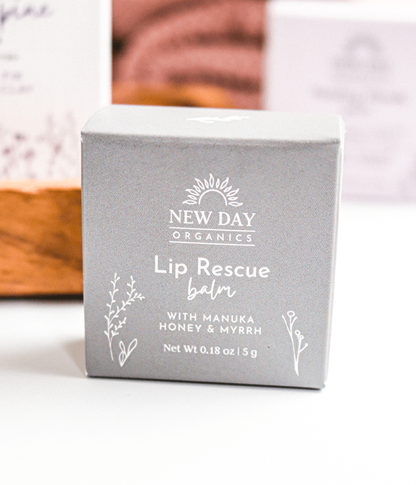 A Box of New Day Organics Lip Rescue Balm