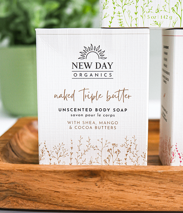 A Box of New Day Organics Naked Triple Butter Unscented Body Soap on a Wooden Serving Tray